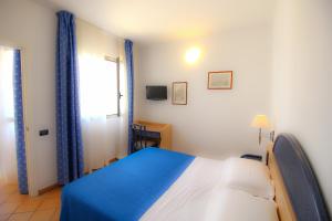 a bedroom with a blue and white bed and a window at Hotel Paladini di Francia in Lampedusa