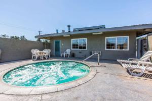a small swimming pool with chairs and a house at Rodeway Inn Ontario Mills Mall in Guasti +3 photos