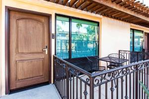 a balcony with a door and a table and chairs at The Cove Hotel in Long Beach
