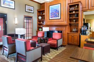 南舊金山的住宿－北舊金山機場康福特茵套房酒店，客厅配有红色椅子和壁炉