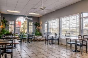 a restaurant with tables and chairs and windows at Clarion Hotel By Humboldt Bay in Eureka