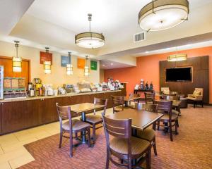 a restaurant with tables and chairs and a counter at Comfort Suites in Clovis