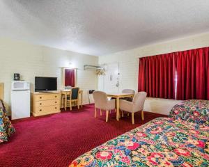 a hotel room with a bedroom with a bed and a table at Jefferson Inn in Yreka