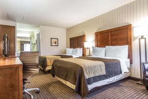 um quarto de hotel com duas camas e uma secretária em Quality Inn Half Moon Bay-Miramar Beach em Half Moon Bay