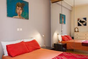 アテネにある2 Bedroom Artist's Apartment - So Athensのベッドルーム1室(赤い枕と鏡付きのベッド2台付)