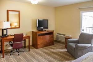 a hotel room with a television and a desk and chair at Comfort Inn Cockatoo Near LAX Airport in Hawthorne