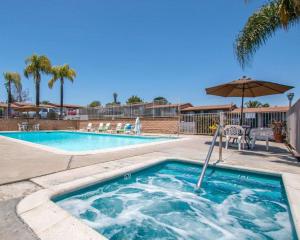 una piscina con sombrilla, mesa y sillas en Rodeway Inn Fallbrook Downtown, en Fallbrook