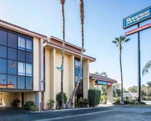 a hotel with palm trees in front of it at California Inn and Suites Bakersfield in Bakersfield