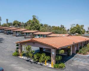 a building with a tiled roof in a parking lot at Rodeway Inn Fallbrook Downtown in Fallbrook