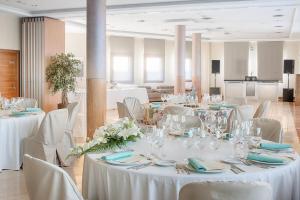 a banquet hall with white tables and chairs with flowers at Hotel Zalle Don Fernando in Granda