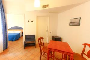 ランペドゥーザにあるホテル パラディーニ ディ フランシアのリビングルーム(テーブル付)、ベッドルーム1室