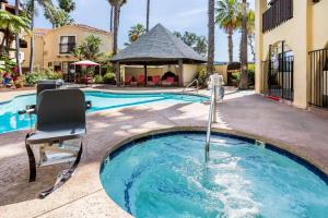 a swimming pool with a chair next to a house at Quality Inn Fallbrook in Fallbrook