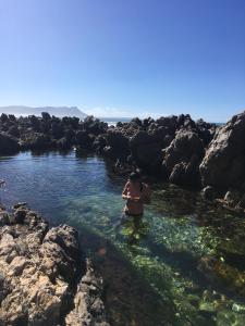 un homme debout dans une masse d'eau dans l'établissement Rondawel with sea view, à Kleinmond