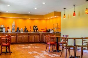 a restaurant with orange walls and wooden tables and chairs at Rodeway Inn - Rohnert Park in Rohnert Park