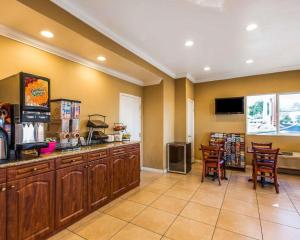 a kitchen with wooden cabinets and a table and chairs at Rodeway Inn & Suites Corona in Corona