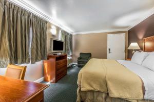 a hotel room with a bed and a desk at Rodeway Inn Ventura in Ventura