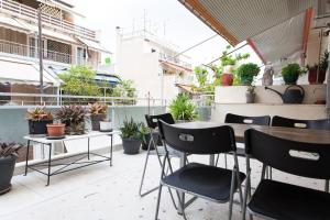 アテネにある2 Bedroom Artist's Apartment - So Athensのパティオ(テーブル、椅子、鉢植えの植物付)