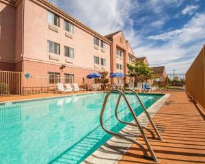 a swimming pool at a hotel with chairs and umbrellas at Rodeway Inn in Watsonville