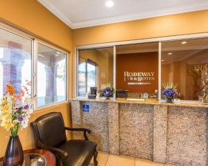 a lobby with a waiting area with a chair at Rodeway Inn & Suites Corona in Corona +26 photos