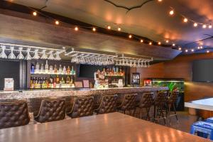 a bar with leather chairs and a counter with liquor bottles at Quality Inn & Suites Montebello - Los Angeles in Montebello