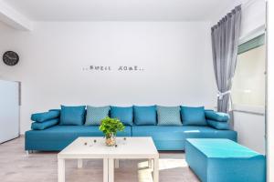 un soggiorno con divano blu e tavolo di Villa Veronique a Dramalj