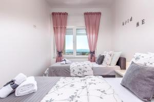 a bedroom with two beds and a window at Villa Veronique in Dramalj +106 photos