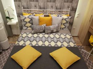 un grande letto con cuscini gialli sopra di 'Golden Aurora' Apartment With Elegant Style ad Atene