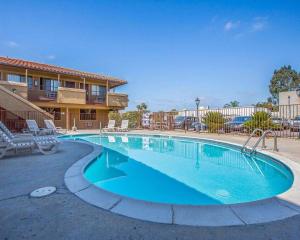 a swimming pool at a resort with chairs and a building at Rodeway Inn Santee San Diego East in Santee +15 photos