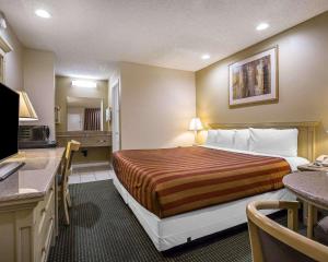 a hotel room with a bed and a kitchen at Rodeway Inn Santee San Diego East in Santee