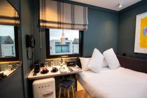 a hotel room with a bed and a desk and two windows at The Devlin Dublin in Dublin