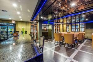 a restaurant with a bar and tables and chairs at voco Laguna Hills by IHG in Laguna Hills