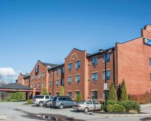 ein großes Backsteingebäude mit Autos auf einem Parkplatz in der Unterkunft Comfort Inn Port Hope in Port Hope