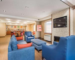Sala de espera con sillas azules y TV de pantalla plana en Comfort Inn Bathurst, en Bathurst