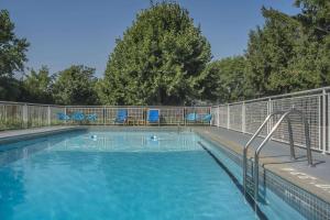 una piscina con sillas azules y una valla en Rodeway Inn Fallsview, en Niagara Falls