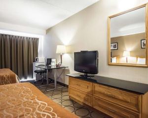 a hotel room with a bed and a flat screen tv at Comfort Inn in Campbellton
