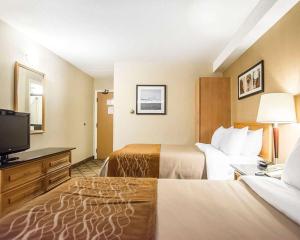 um quarto de hotel com duas camas e uma televisão de ecrã plano em Comfort Inn em Campbellton