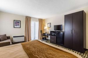 um quarto de hotel com uma cama grande e uma televisão em Comfort Inn Barrie em Barrie