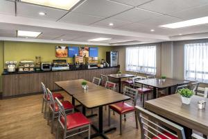 a restaurant with wooden tables and chairs and a counter at Comfort Inn Fredericton in Fredericton