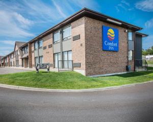 a large brick building with a bench in front of it at Comfort Inn Edmundston in Edmundston