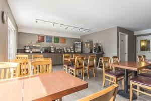 a restaurant with wooden tables and chairs and a kitchen at Comfort Inn in Huntsville