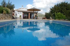 a swimming pool in front of a house at Cortijo Lagarín in El Gastor
