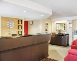 a hotel lobby with a reception desk and red chairs at Comfort Inn in Brantford