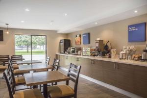 a restaurant with wooden tables and chairs and a kitchen at Comfort Inn Chatham in Chatham