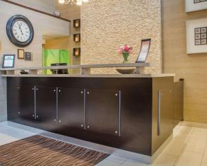 a lobby with a reception desk with a clock on the wall at Comfort Inn in Guelph