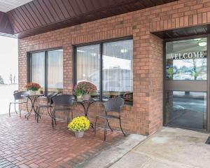 eine Terrasse mit Tischen und Stühlen in einem Backsteingebäude in der Unterkunft Comfort Inn in Pembroke