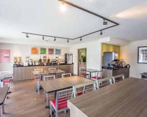 a restaurant with tables and chairs and a kitchen at Comfort Inn Gatineau in Gatineau