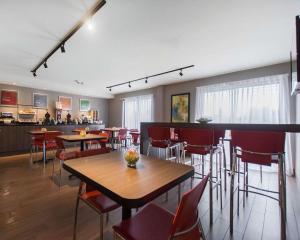 a dining room with tables and chairs and a kitchen at Comfort Inn Val D'Or in Val-dʼOr +31 photos