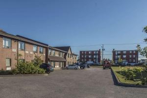 un aparcamiento con coches estacionados frente a los edificios en Comfort Inn Sept-Iles, en Sept-Îles