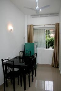 a dining room with a black table and chairs at Bamba Flat in Colombo