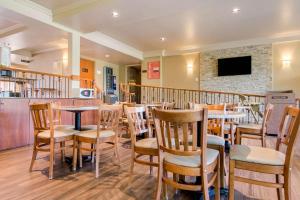 un restaurant avec des tables, des chaises et une cheminée dans l'établissement Comfort Inn & Suites Shawinigan, à Shawinigan